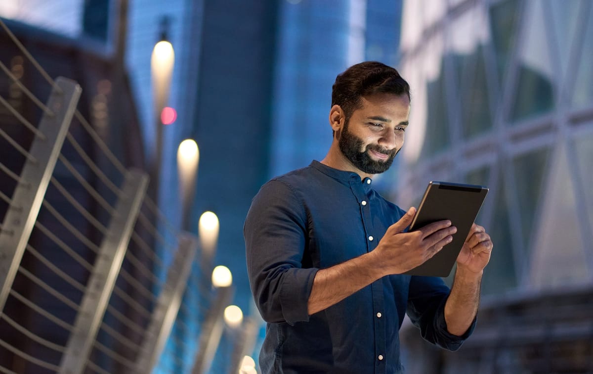 Professional reviewing retained project records on a tablet outside a city office at night