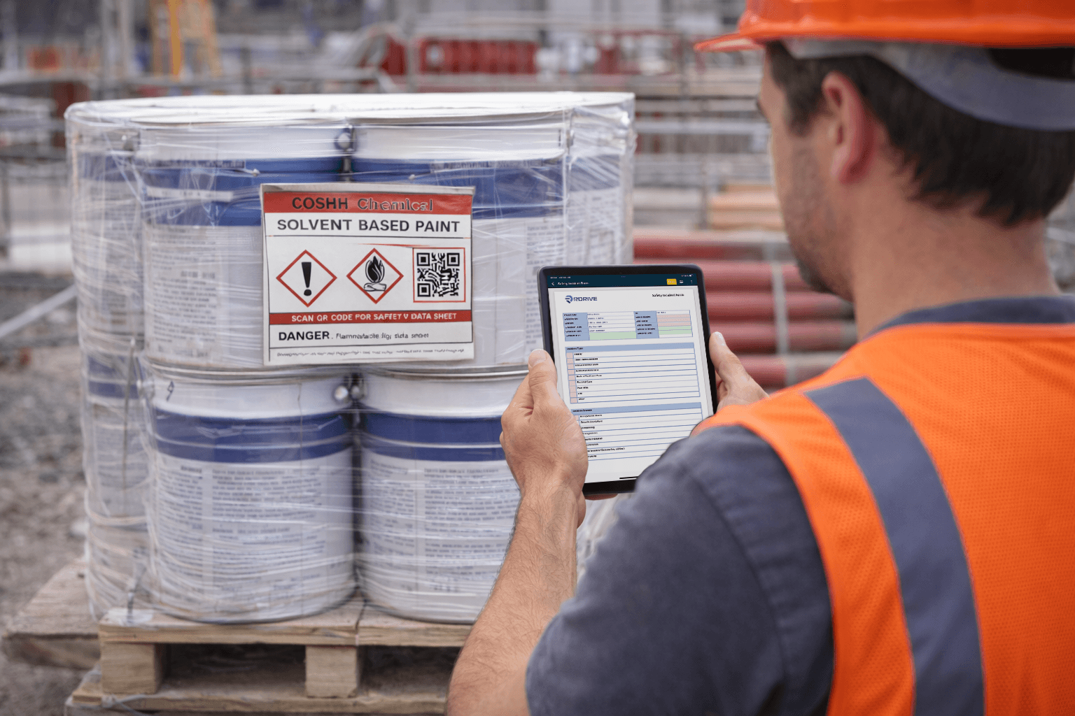Worker checking a COSHH label on solvent paint drums against its register entry on a tablet
