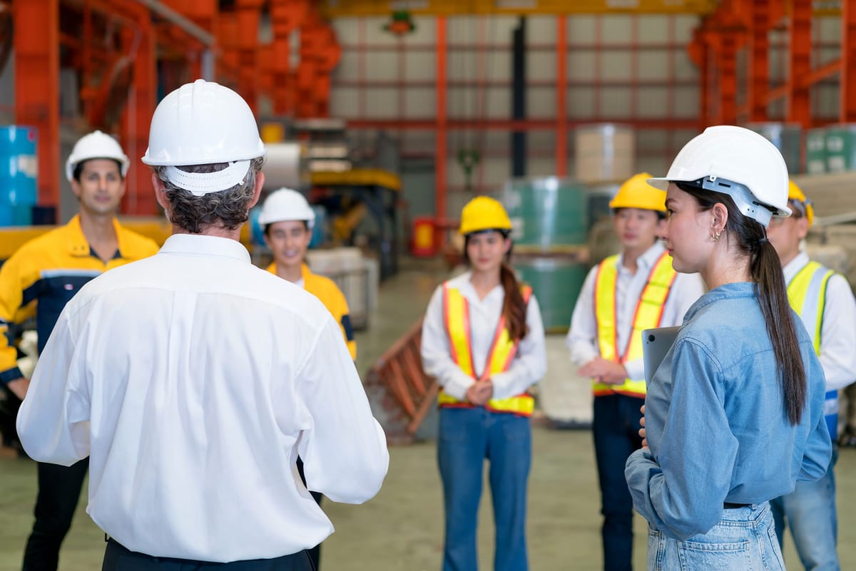Instructor briefing a group of workers in a warehouse, the kind of session RDrive Academy custom courses cover