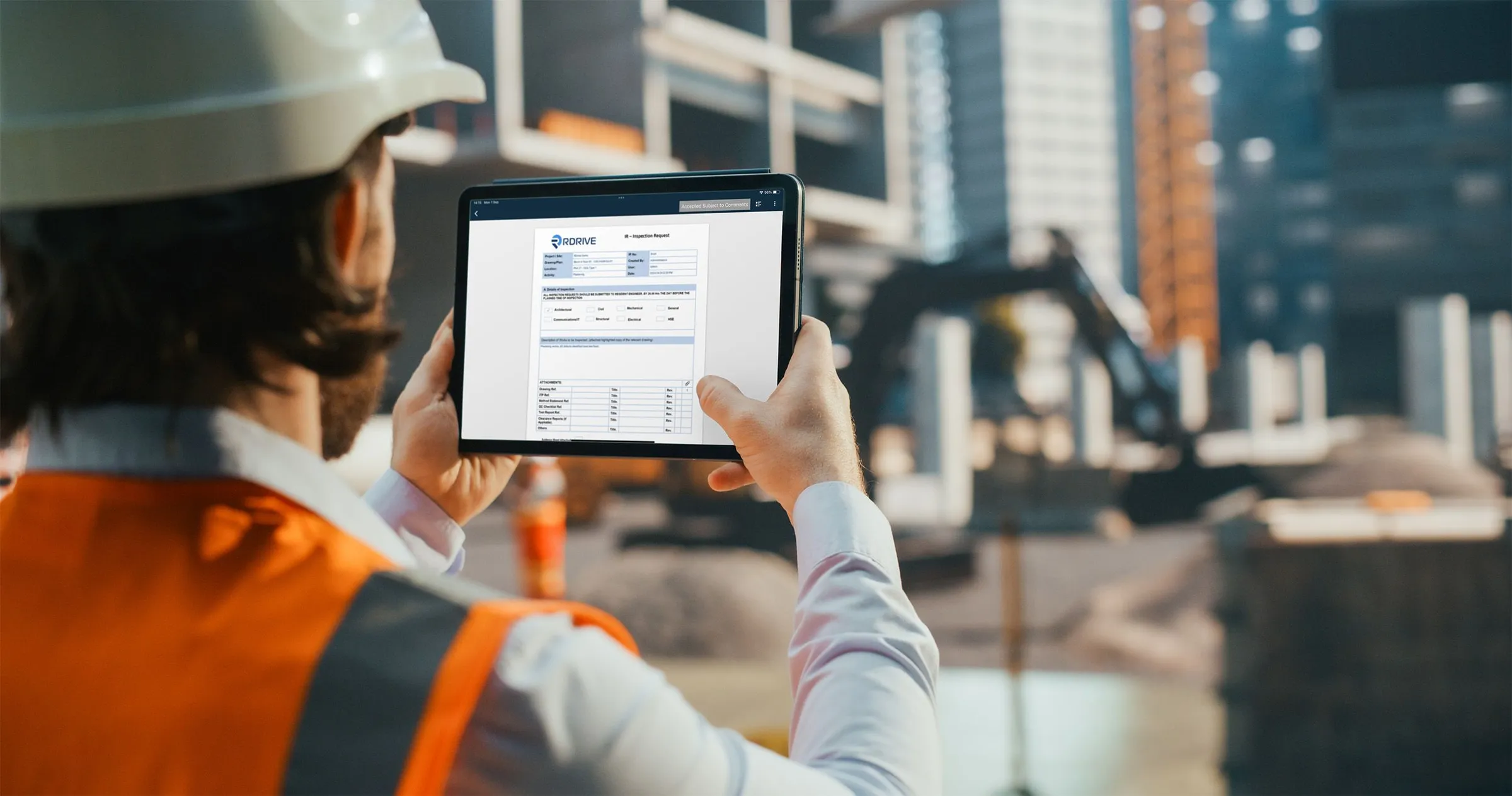 Engineer on a construction site holding a tablet showing a signed-off RDrive record as proof of work