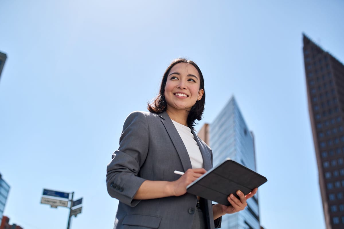Training administrator with a tablet outside a city office, managing organisation-wide RDrive Academy access