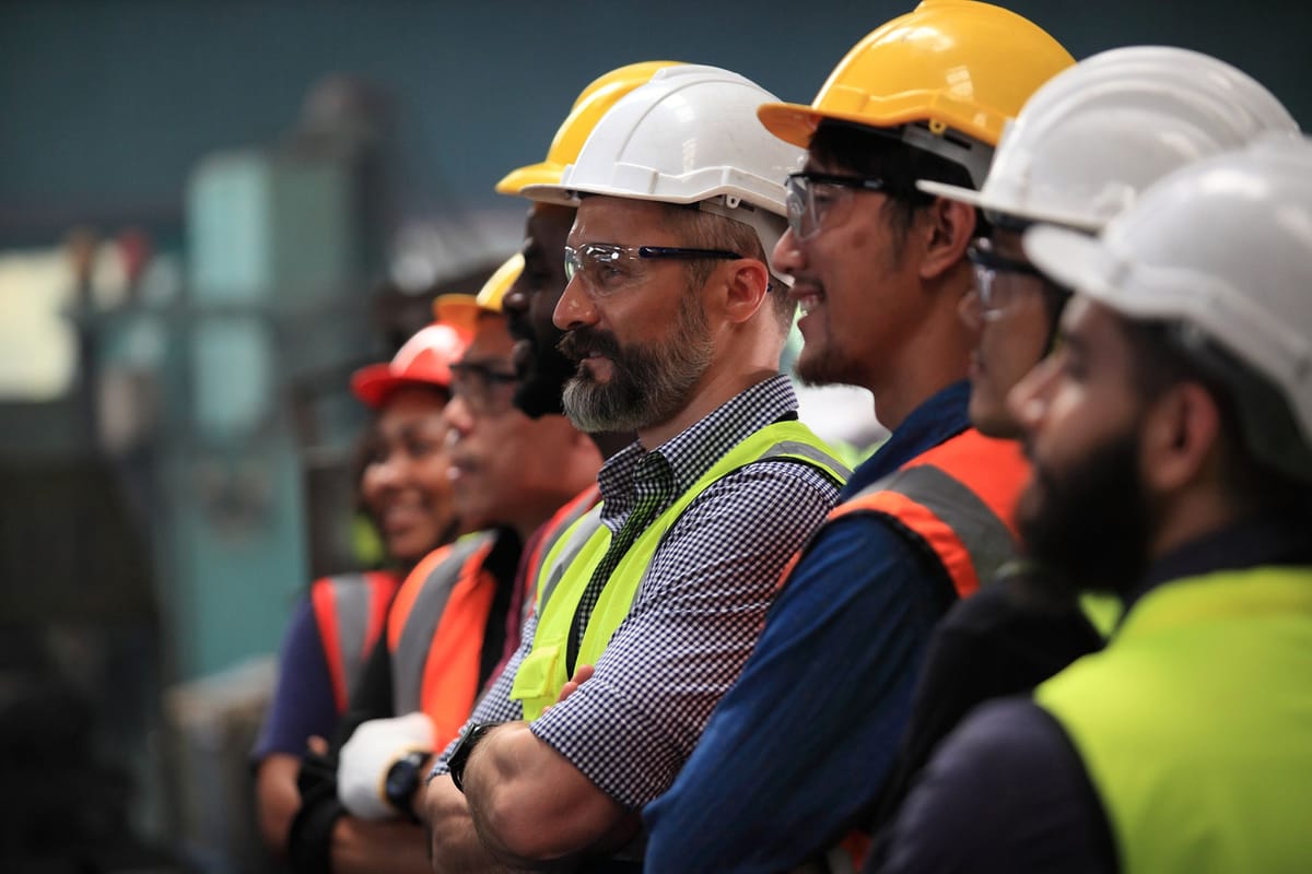 Line of workers in hard hats listening during a site briefing, the teams RDrive is built for